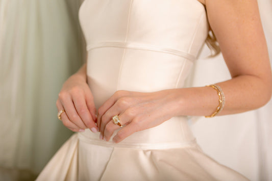 Close up of a bride wearing an east-to-west emerald lab diamond bezeled engagement ring.