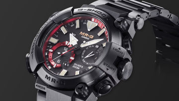 Close-up of the Casio MR-G G-SHOCK Diver’s 200M watch featuring a black titanium case and bracelet, black dial with red accents, luminous markers, and rugged pushers labeled “Light” and “Start.”
