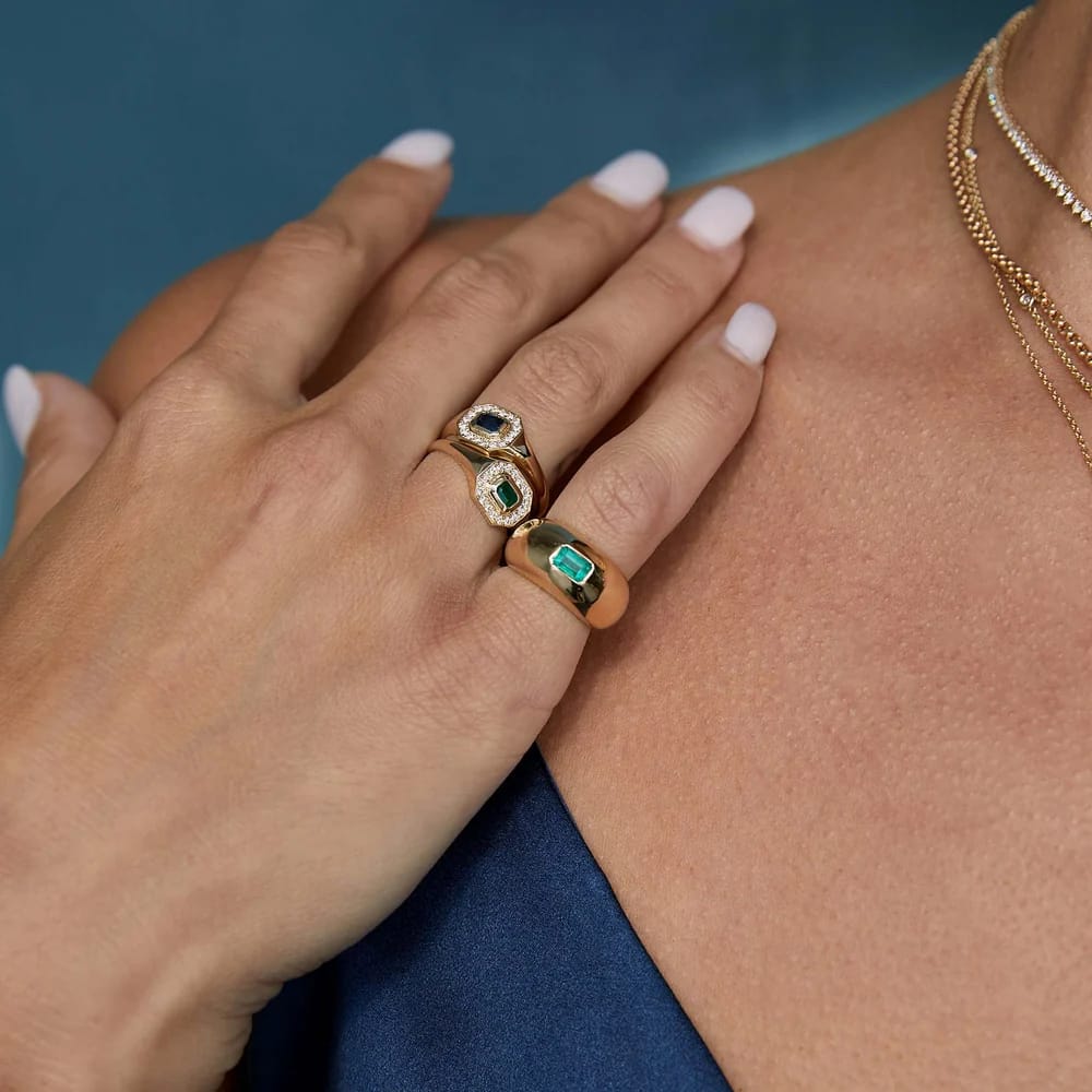 14K GOLD HORIZONTAL EMERALD CUT HALO SIGNET RING WITH AN EMERALD IN THE MIDDLE FRAMED BY WHITE PAVÉ DIAMONDS (.15 CTW