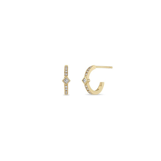 14K GOLD HUGGIE HOOP EARRINGS WITH A BEZEL SET PRINCESS DIAMOND IN THE MIDDLE AND 4 WHITE PAVE DIAMONDS ON EACH SIDE